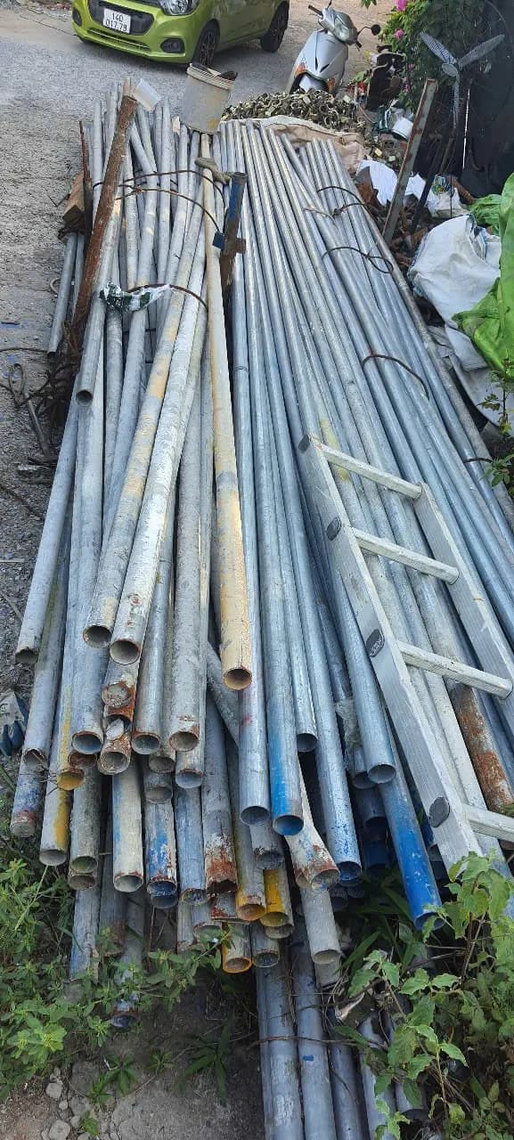 Ống thép dài xếp cạnh lối đi trong kho
